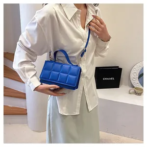 Détail d'un sac à main matelassé bleu roi avec garniture dorée et bandoulière