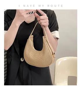 Detail of apricot crescent bag featuring crocodile texture and golden hardware accents