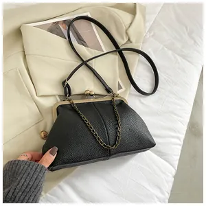 Close-up of black lychee texture shell bag with vintage bronze clasp and chain strap