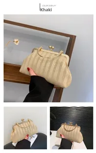 Détail d'un sac tressé kaki avec fermoir en métal et bandoulière chaîne élégante