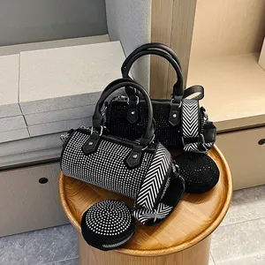 Detail of studded cylinder bags in black and silver with geometric pattern wide straps