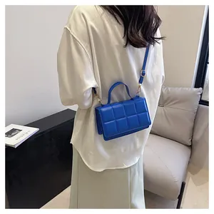 Détail d'un sac à bandoulière matelassé bleu vif avec des finitions dorées