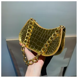 Detailed view of the metallic gold crescent bag with crocodile pattern and chain strap