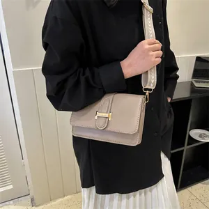 Sac bandoulière beige minimaliste avec fermoir en H doré et large sangle tissée chic