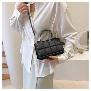 Détail d'un sac à main matelassé noir avec boucle dorée et texture de couture raffinée
