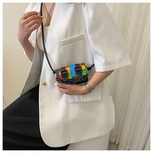 Detail of mini crossbody bag with colorful checkerboard pattern and black chain strap