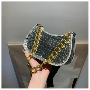 Macro detail of silver crocodile pattern handbag with chunky gold chain strap and zipper