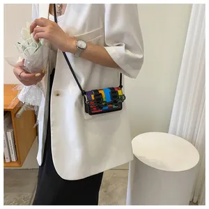 Mini flap crossbody bag featuring rainbow mosaic patchwork and bold black chain strap