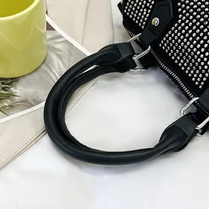Close-up of black leather pillow bag featuring shimmering silver rhinestones and metal zip