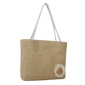 Large beige woven straw tote bag with white cotton rope handles and daisy floral detail