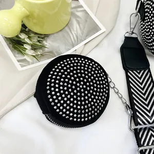 Close-up of a black circular coin purse with sparkling silver rhinestones and metal chain