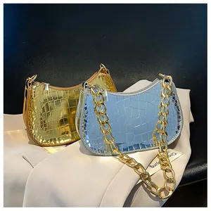 Detail of metallic crocodile texture crescent bags with decorative chunky chains
