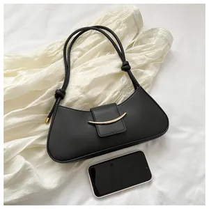Borsa minimalista in pelle PU nera con fibbia dorata accanto a un telefono per confronto taglie
