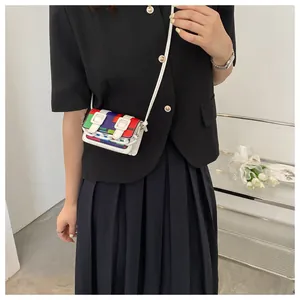 Detailed shot of mini patchwork crossbody bag with vibrant color blocks and white chain link