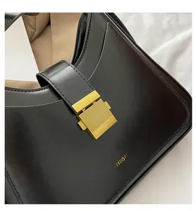 Detailed close-up of a black leather bucket bag with a gold rectangular lock and gold logo