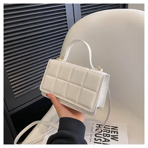 Détail d'un sac bandoulière en cuir PU blanc matelassé avec fermoir doré et poignée chic