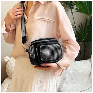 Vue détaillée du sac bandoulière en cuir noir avec strass et sangle rayée élégante