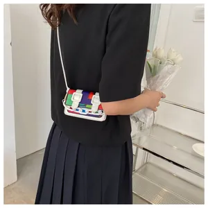 Detail of colorful patchwork mini crossbody bag with white chain and buckle straps
