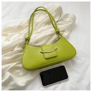 Borsa sottobraccio verde lime con dettagli dorati e smartphone per confronto dimensioni