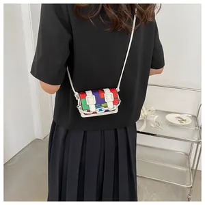 Close-up of a mini color-block crossbody bag with a white chain and adjustable strap
