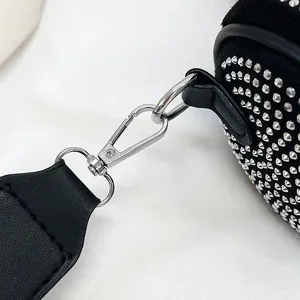 Close-up of black rhinestone crossbody bag with silver hardware and wide strap