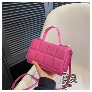 Détail du sac à main en cuir matelassé rose avec anneau en D doré et bandoulière fine