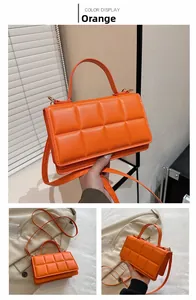 Détail du sac bandoulière matelassé orange montrant la texture et la poignée