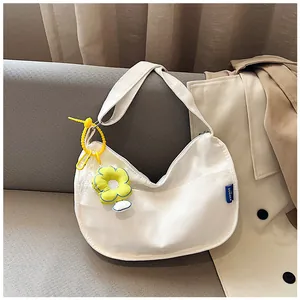 Sac fourre-tout en toile blanc avec breloque marguerite jaune et étiquette de marque