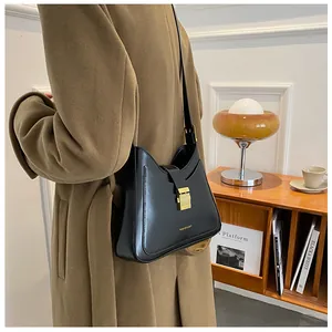 Close-up of black crescent bucket bag with gold clasp and Fashion & Bag lettering