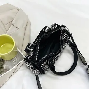 Top view of rhinestone cylinder bag interior showing black lining and wide strap