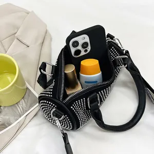 Detail of rhinestone cylinder bag interior showing phone, perfume and storage space