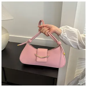 Dettaglio della borsa rosa in ecopelle con fibbia a mezzaluna d'oro e manico annodato