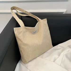 Detailed close-up of retro corduroy tote bag texture with minimalist fashion label