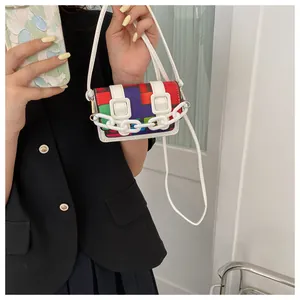 Close-up of mini crossbody bag with multi-color geometric patchwork and white chain detail
