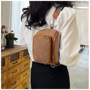 Détail d'un sac de poitrine marron avec strass et sangle géométrique porté en bandoulière