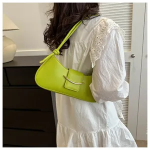 Borsa sottobraccio verde lime in ecopelle con fibbia dorata indossata da una modella