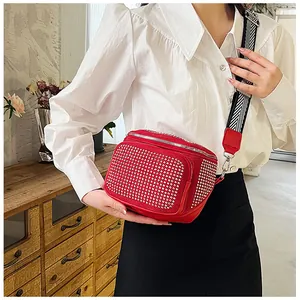 Détail du sac bandoulière rouge avec strass, double fermeture éclair et sangle rayée