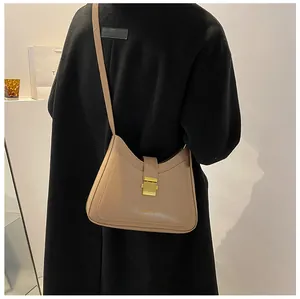 Detail of khaki leather hobo bucket bag with a decorative gold metal buckle closure