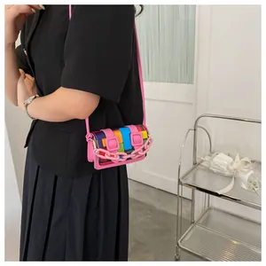 Detail of colorful geometric pattern mini crossbody bag with a pink plastic chain