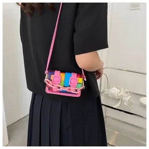 Detailed side view of a mini colorful mosaic crossbody bag with pink chain accents