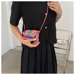 Close-up of pink mini crossbody bag with colorful mosaic tiles on a black outfit