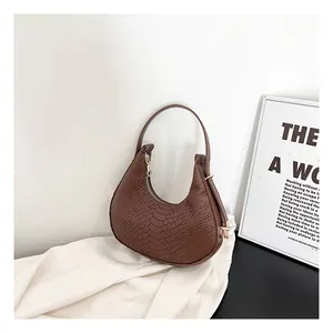 Detail of dark brown faux crocodile leather hobo bag with gold zipper and stylish crescent shape