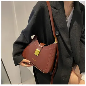 Detail of vintage brown leather bucket bag featuring gold metal buckle on black coat