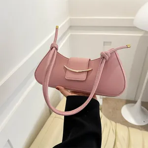 Elegante borsa baguette rosa con fibbia in metallo dorato e tracolla con nodi