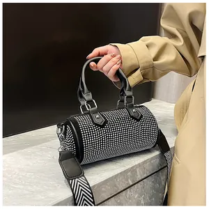 Chic black rhinestone cylinder bag with leather handles and wide patterned strap