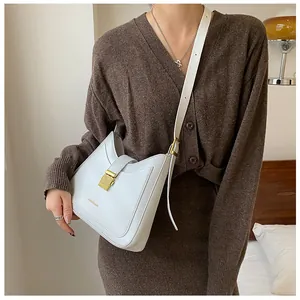 White bucket bag with gold metal buckle and FASHION & BAG lettering on a model