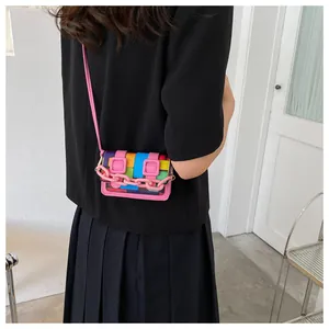 Detailed view of mini crossbody bag with colorful checkerboard pattern and pink chain