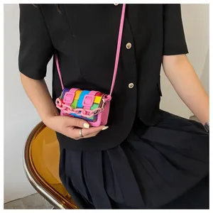 Close-up of a colorful mini patchwork crossbody bag with pink plastic chain and leather strap