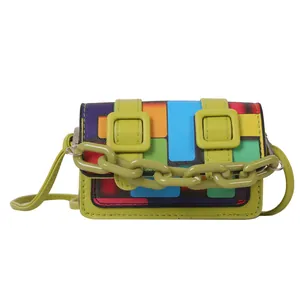 Close-up of mini crossbody bag featuring green frame and colorful geometric mosaic patterns