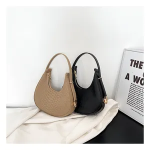 Detail of khaki and black hobo bags featuring crocodile pattern and metal zippers